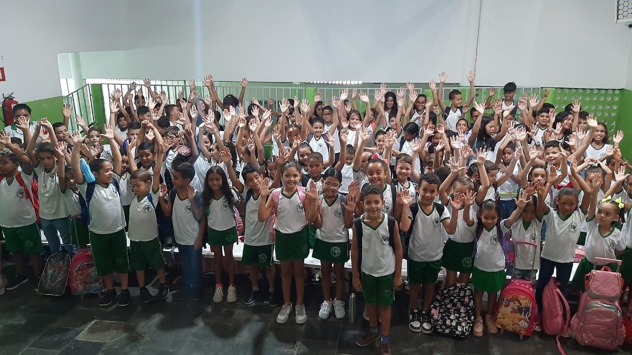 Crianças da escola com as mãos levantadas
